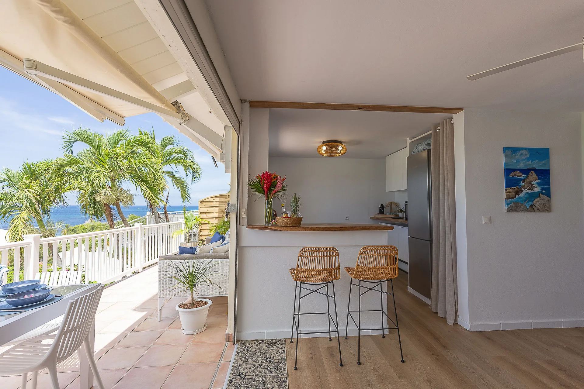 Kitchen opening onto a bright terrace with ocean views