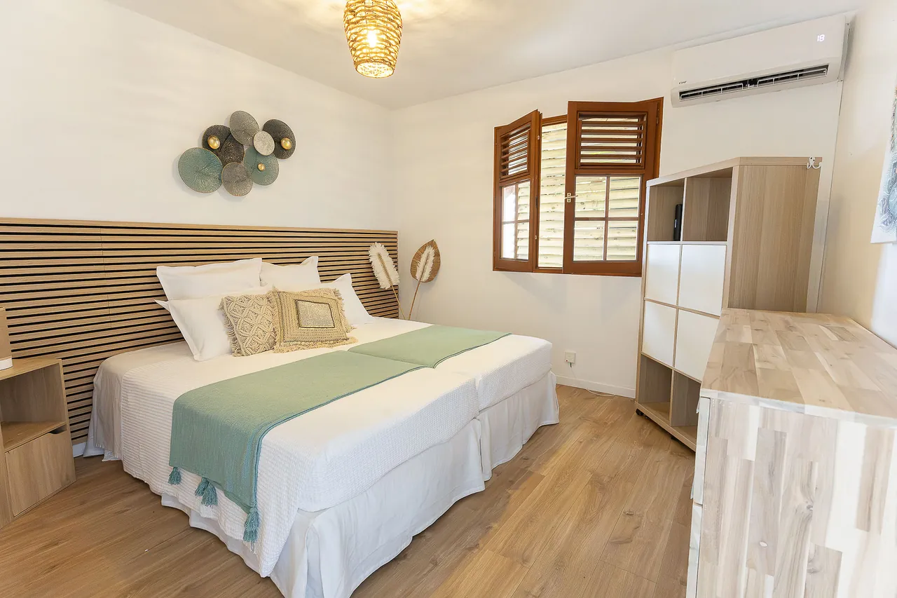 Peaceful bedroom with two beds joined together, storage and air conditioning